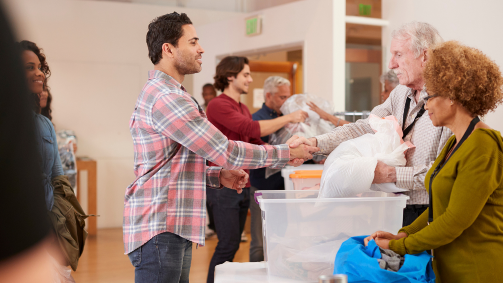 Volunteers handing donated clothing across a table at a community center